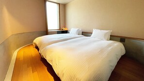 A hotel room with two beds, a nightstand, and a window. - LACER SUITES KAMAKURA (Kamakura)