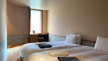 A hotel room with a bed, a desk, and a chair.