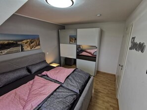 Une chambre à coucher avec un lit, une armoire et un tableau accroché au mur.