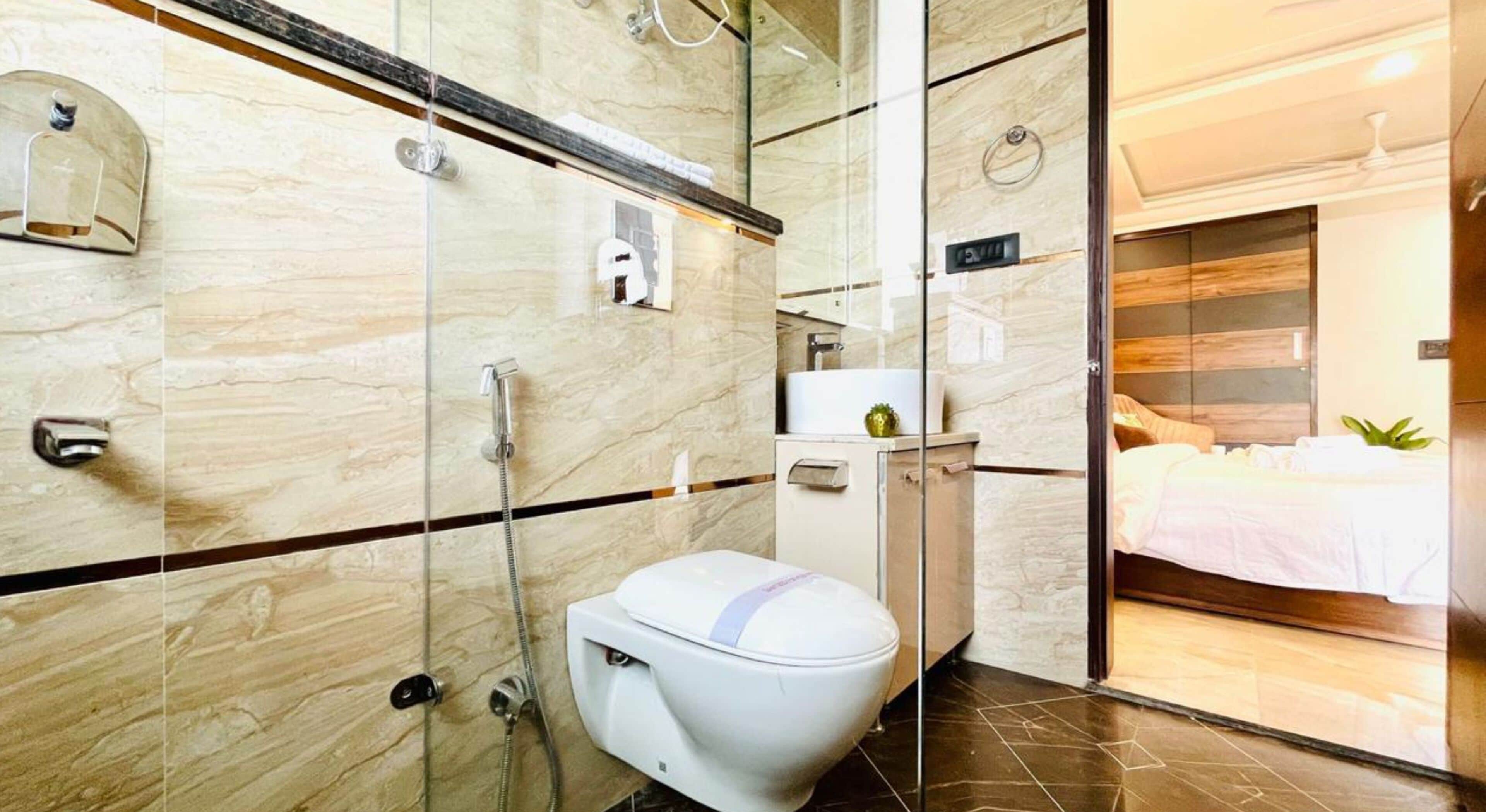 A modern bathroom with a glass shower enclosure, a toilet, and a vanity with a mirror.