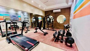 Un gimnasio con cintas de correr, máquinas de pesas y pesas libres.