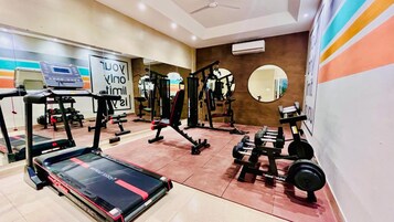 A gym with treadmills, weight machines, and free weights.