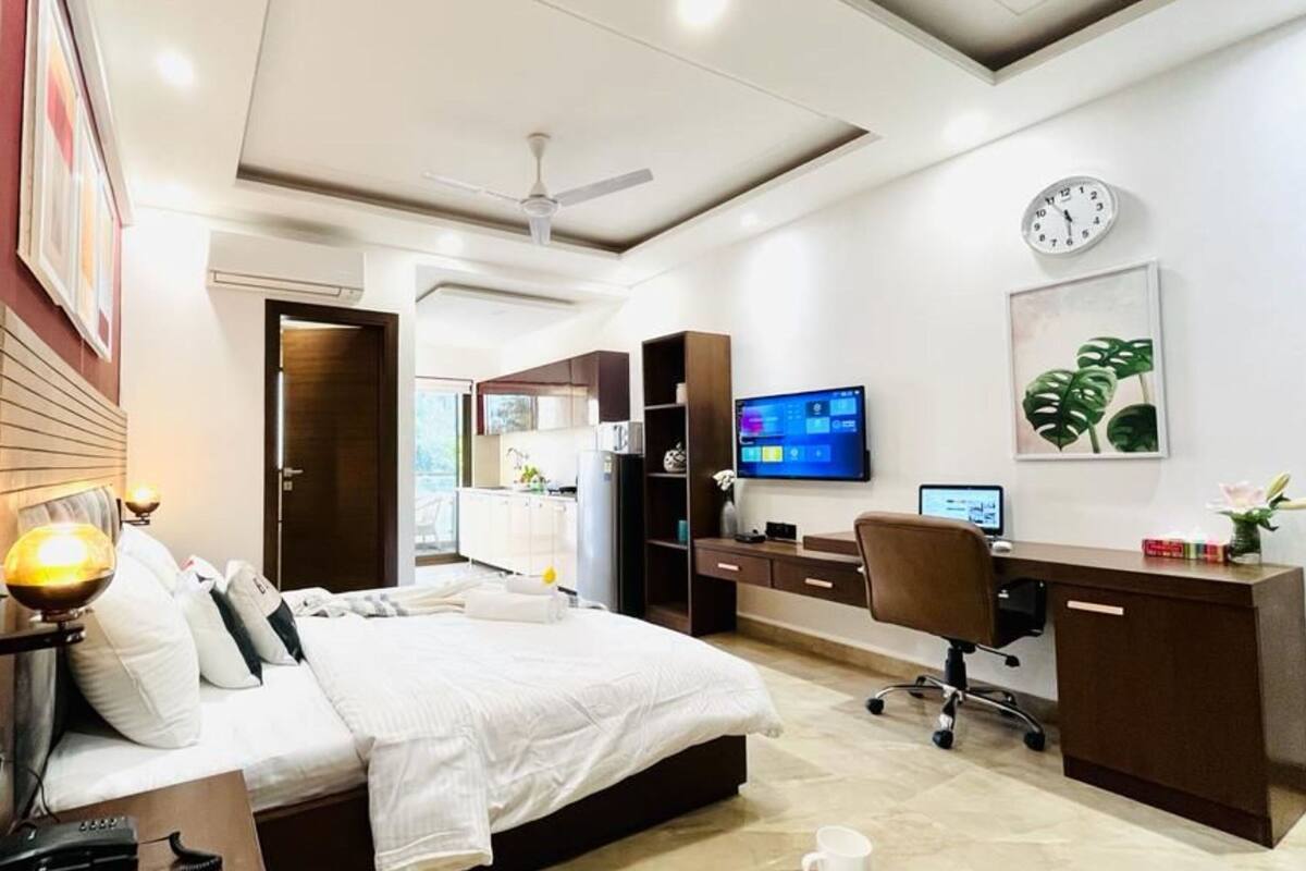 Une chambre d’hôtel moderne équipée d’un lit, d’un bureau, d’une chaise et d’un téléviseur.
