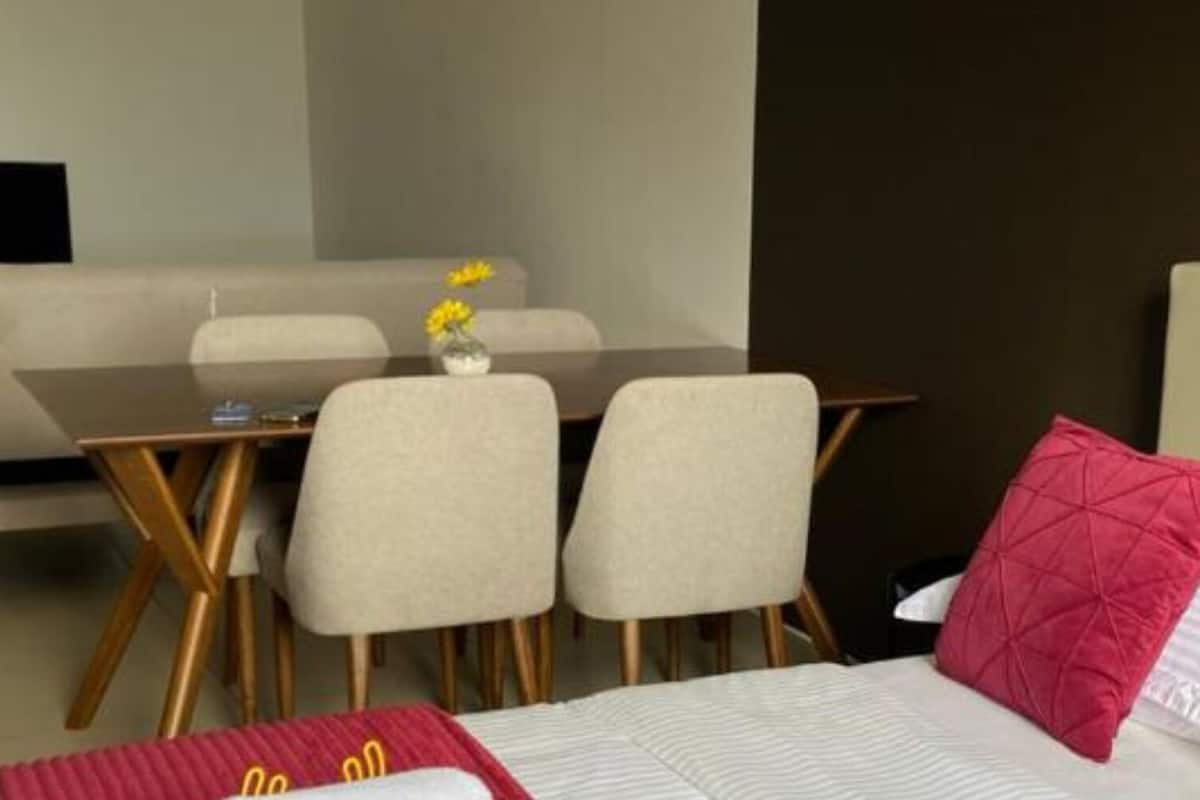 A hotel room with a bed, a desk, and two chairs.