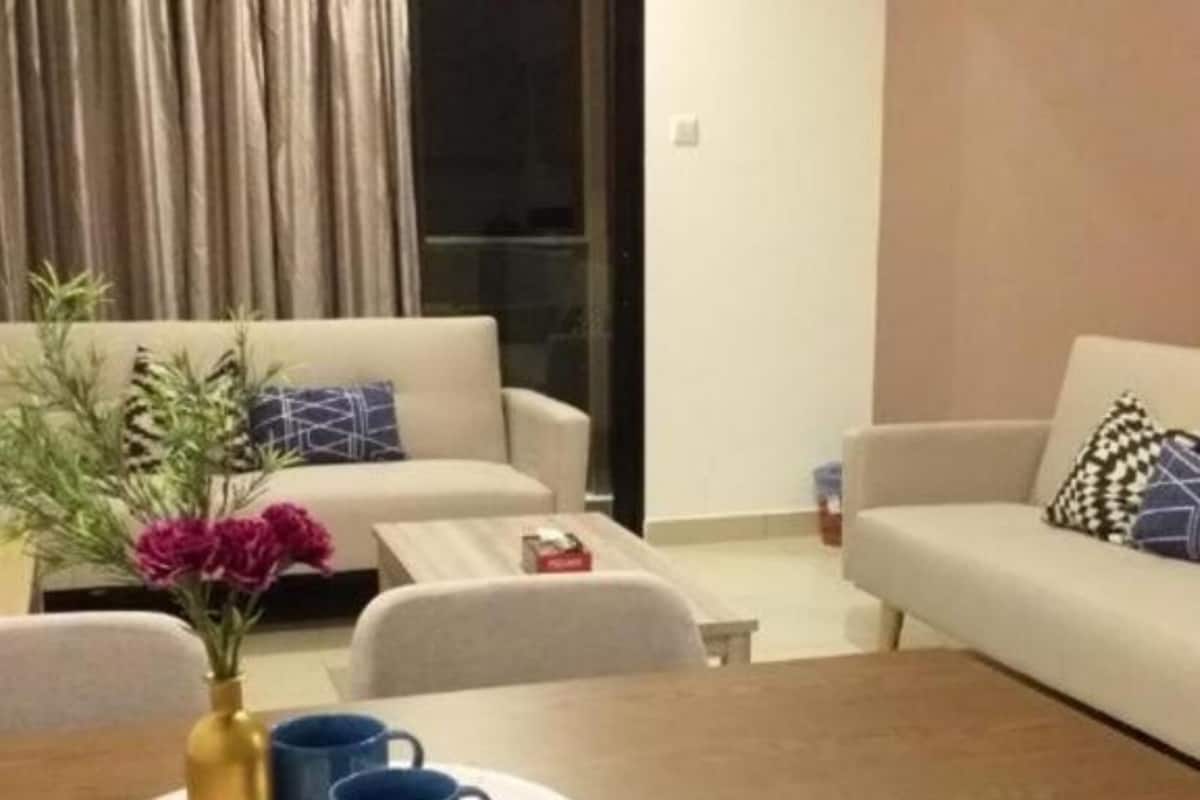 A living room with two sofas, a coffee table, and a dining table with chairs.