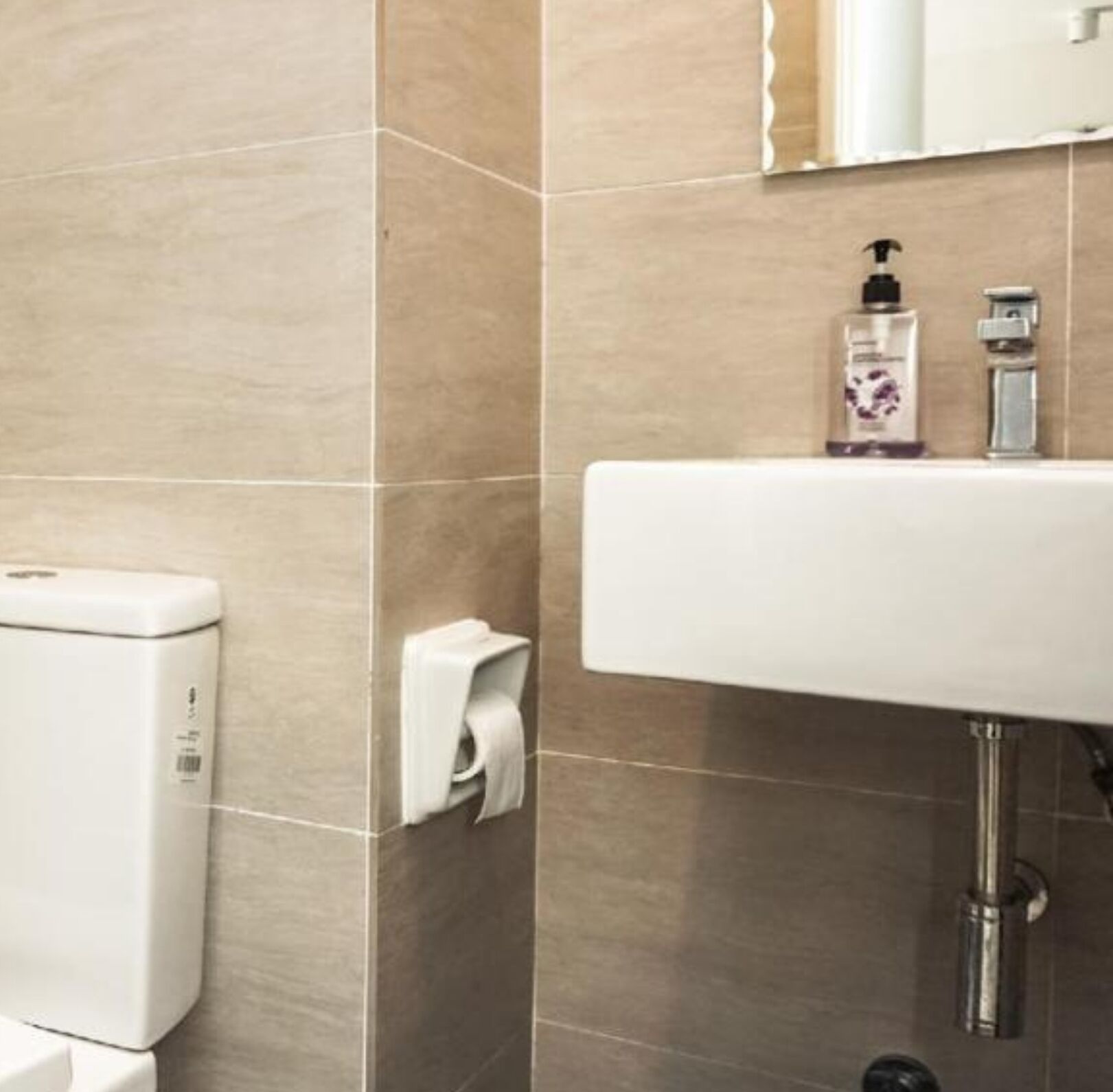 A bathroom with a toilet, a sink, and a hand dryer.