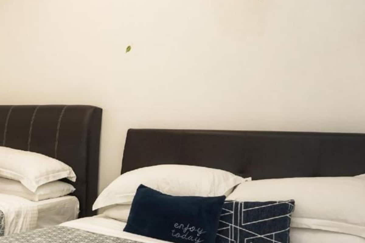 A hotel room with two beds, each with a pillow and a folded towel.