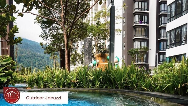 Un jacuzzi al aire libre rodeado de exuberante vegetación y edificios modernos.
