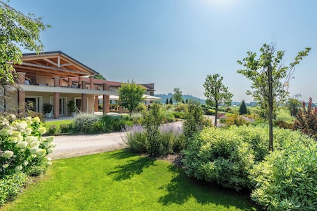 A modern house with a covered patio, lush garden, and a clear view of the landscape.. Relais Agriturismo Maria Vittoria