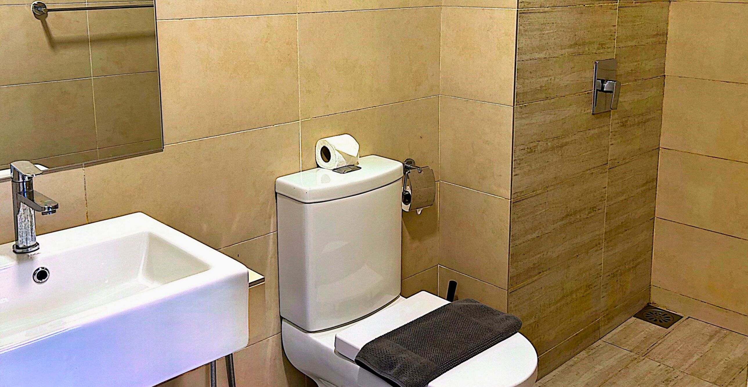A bathroom with a white sink, toilet, and shower.