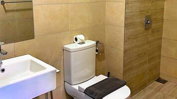 A bathroom with a white sink, toilet, and shower.