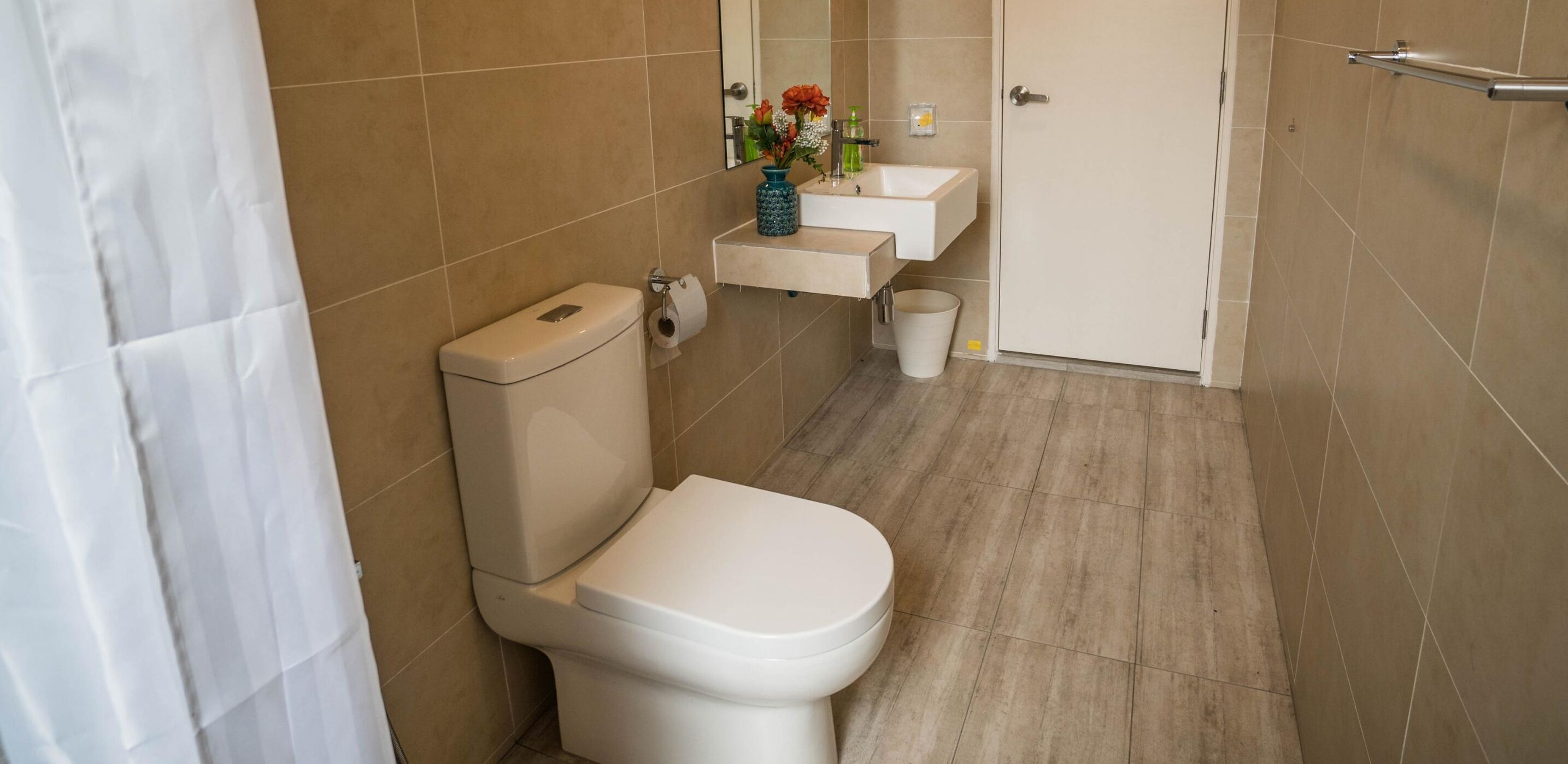 Ein modernes Badezimmer mit Toilette, Waschbecken und Duschbereich.