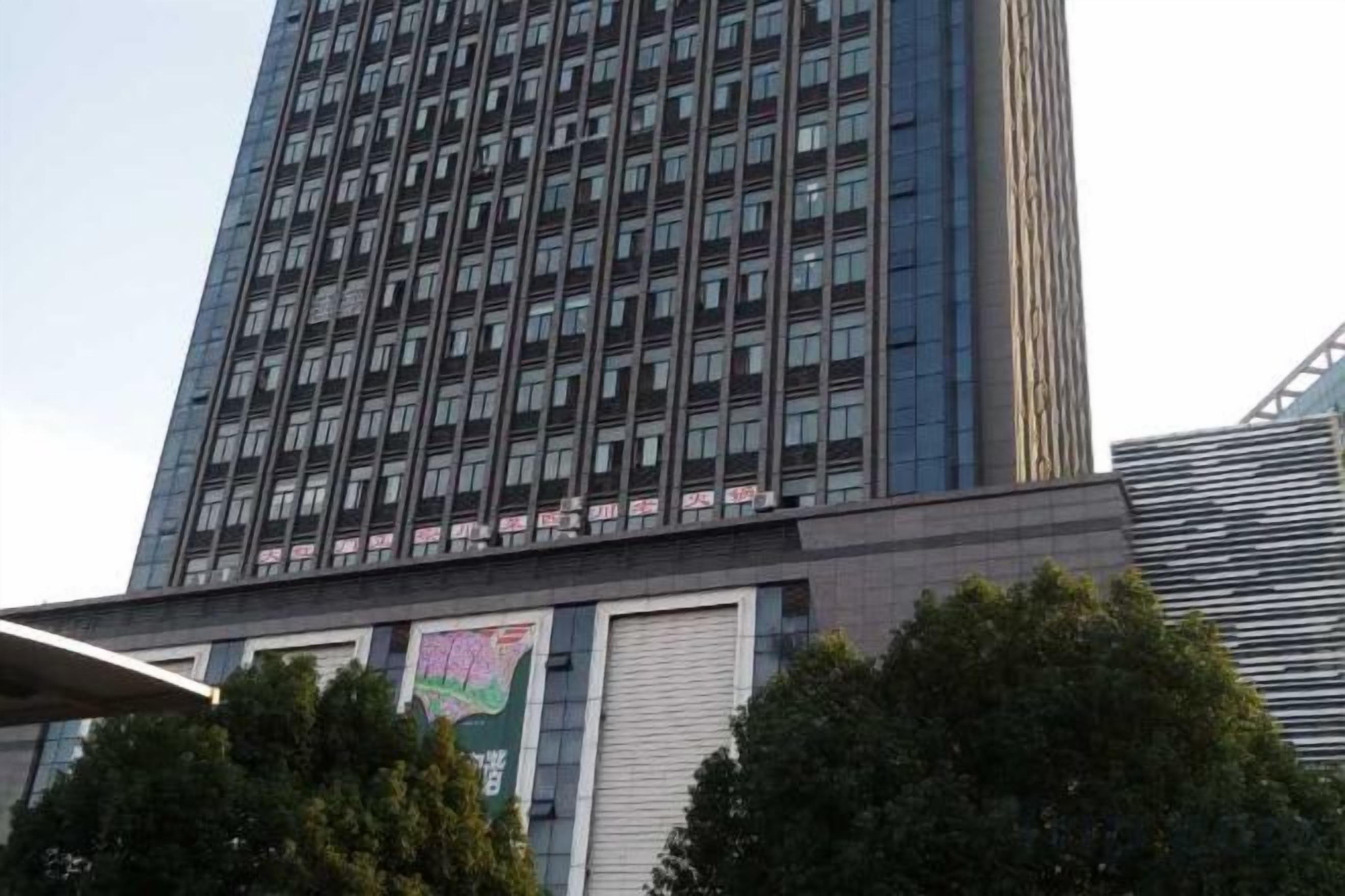 A tall building with a grid of windows and a flat roof.
