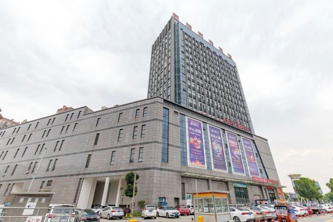 A multi-story hotel with a prominent central tower, a ground-level entrance, and several visible windows.