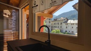 Eine Küche mit Blick aus dem Fenster auf eine Stadt und Berge.
