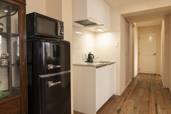 A kitchen with a black refrigerator, a microwave, and a kettle on the counter. - La Krasse Angelroad WEST (Tonosho)