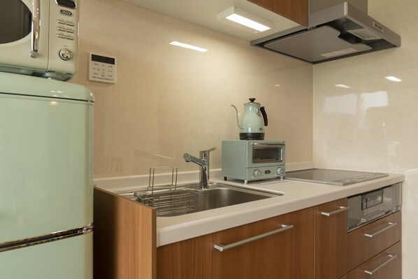 A modern kitchen with a built-in oven, a coffee maker, and a stainless steel sink. - La Krasse Angelroad WEST (Tonosho)