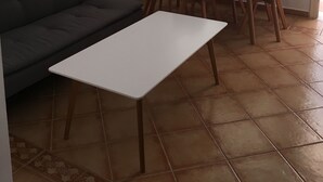 A living room with a sofa, a dining table with chairs, a white air conditioner, and a window with sheer curtains. - Apartamento de 1 Dormitorio Cerca de la Playa (Fuengirola)