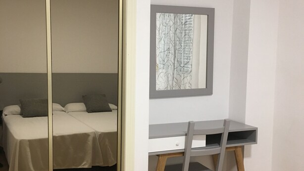 A bedroom with a bed, a desk, and a chair. - Apartamento de 1 Dormitorio Cerca de la Playa (Fuengirola)