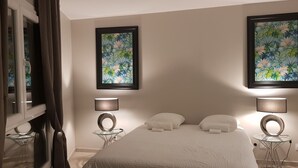 Una camera da letto moderna con un letto, due lampade a parete e due quadri floreali incorniciati.
