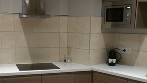 Una cucina moderna con una cappa in acciaio inossidabile, un forno a microonde e una macchina da caffè.