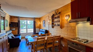 A cozy cabin interior with a living area, dining table, and kitchen. - Spacious Duplex 3BR - Sleeps 6/8 - Balcony (Flaine)