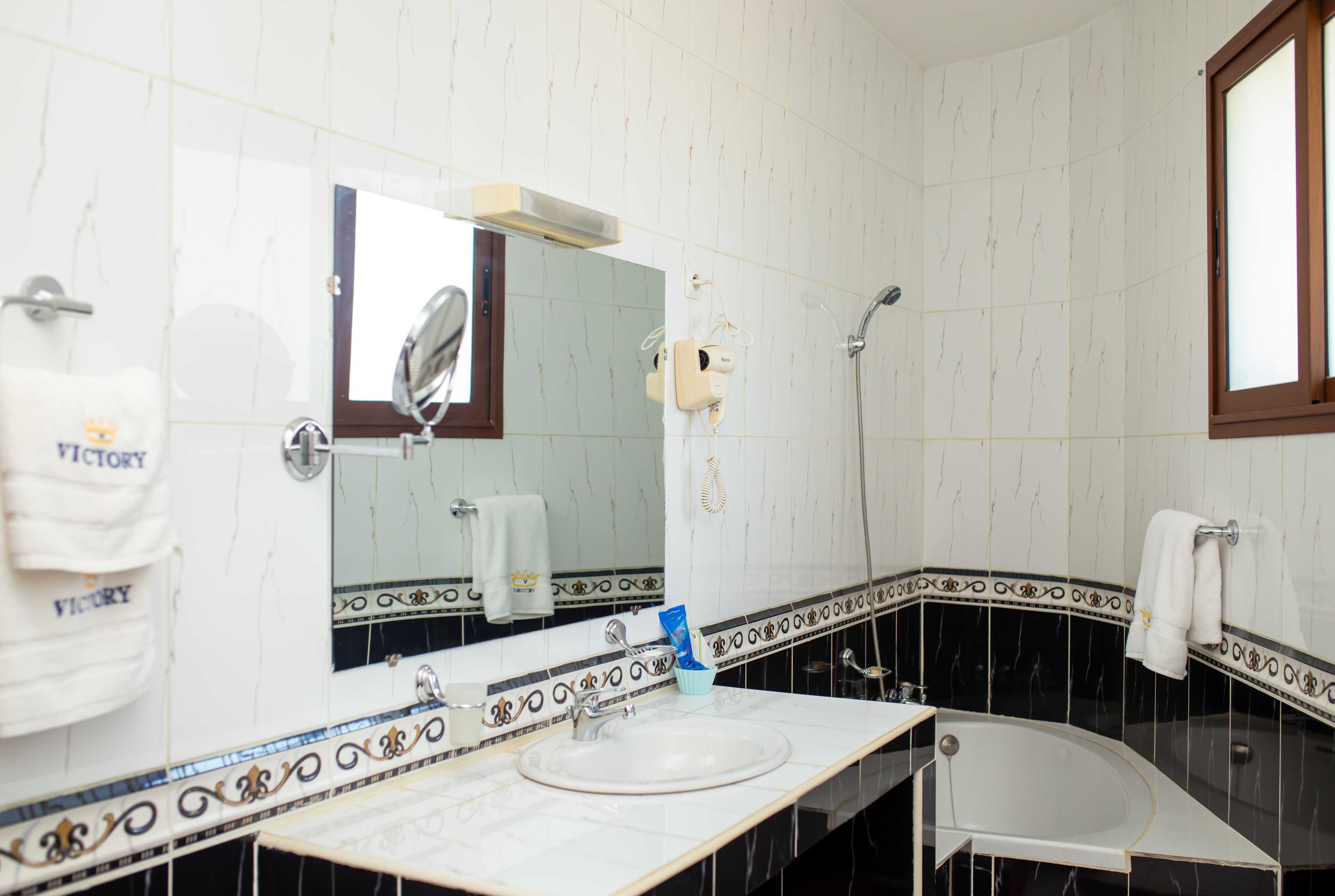 A bathroom with a white sink, a mirror, a shower, and a bathtub.