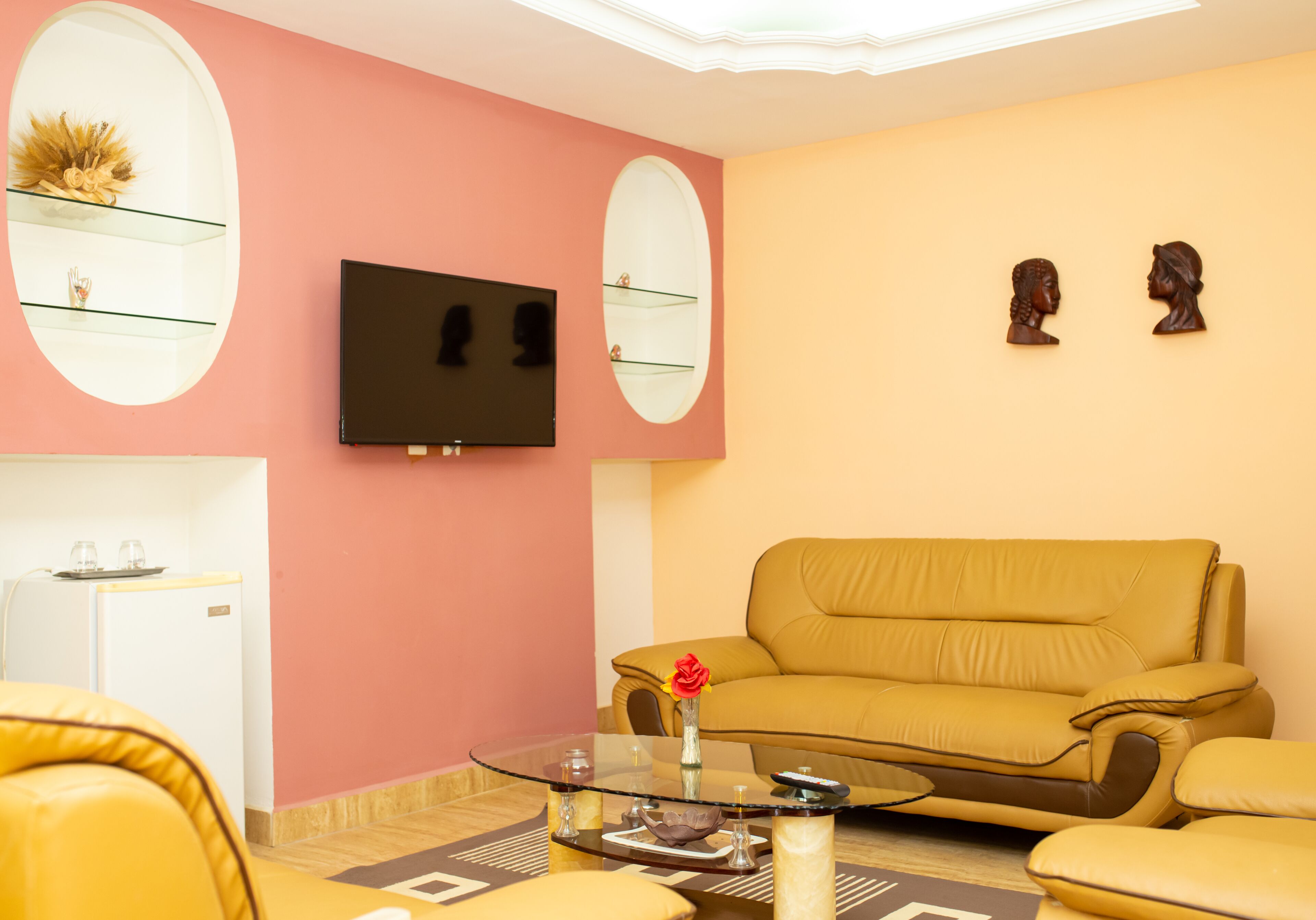 Ein Wohnzimmer mit einer Couch, einem Couchtisch, einem Fernseher und Dekoration auf Regalen.