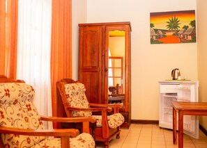 A room with wooden furniture, a cabinet, a painting, and a refrigerator.