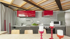 A modern kitchen with grey cabinets, a microwave, and a stainless steel refrigerator. - Inviting 3-bed Apartment in Roma 4mins to Colosseo (Rome)