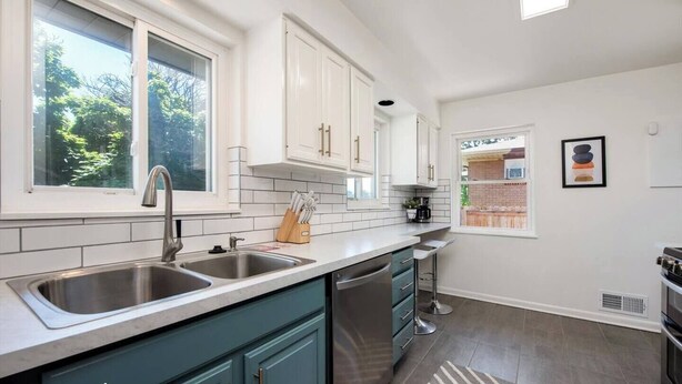 A modern kitchen with white cabinets, a double sink, and a dishwasher. - Peaceful home with fire pit and game room (Denver)