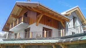 A two-story chalet with a balcony, stone facade, and wooden beams. - Duplex 5 rooms, 10 people, south, pets allowed, private parking (Valloire)