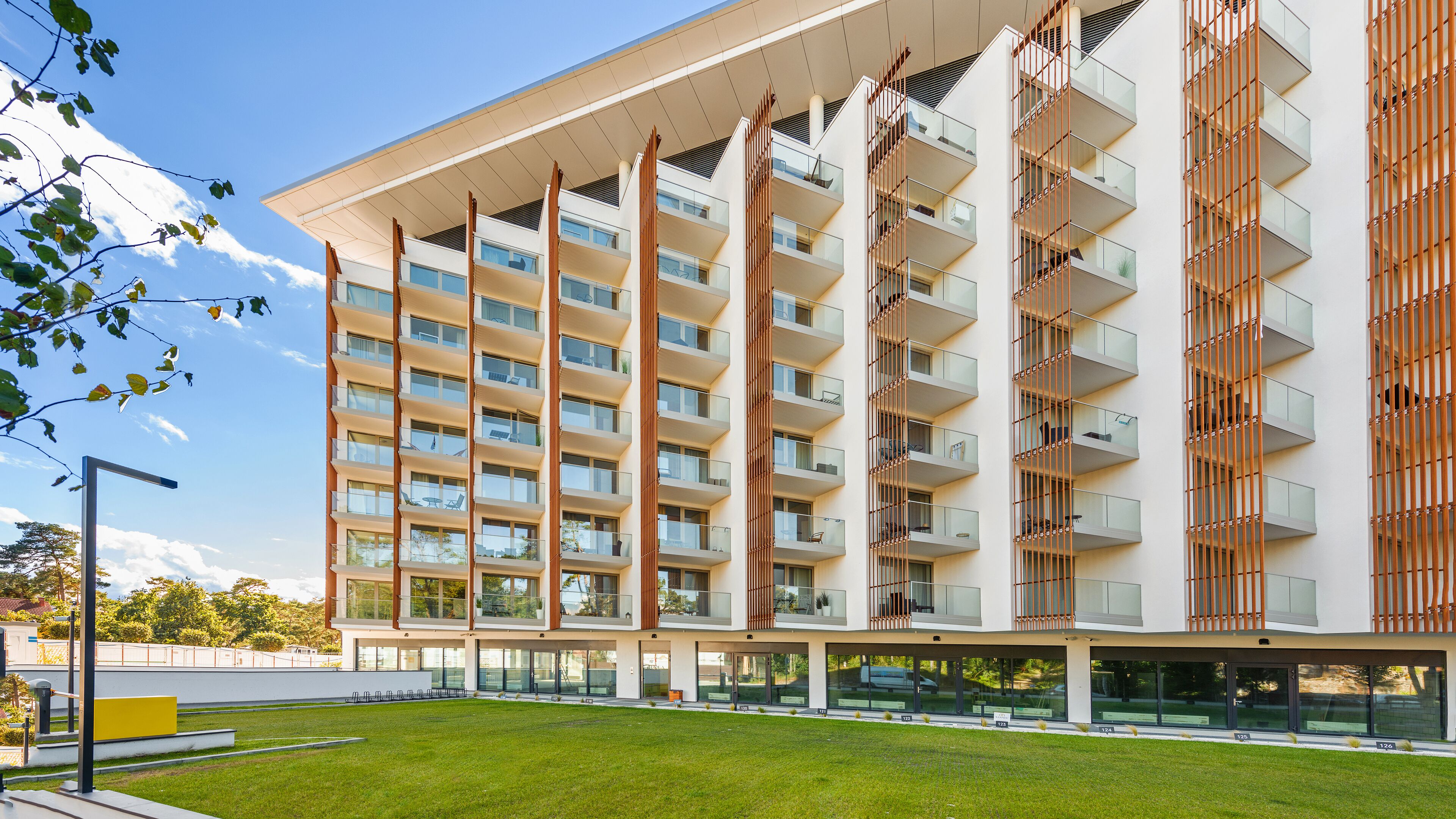 Un immeuble moderne à plusieurs étages, doté de balcons, de grandes fenêtres et d’un toit plat.