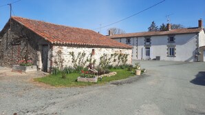 Un paysage rural avec un bâtiment en pierre et une route asphaltée.