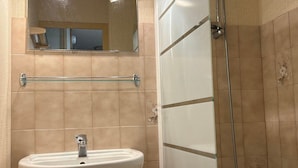 A bathroom with a white sink, a glass shelf, a mirror, and a shower area. - 2-room cabin apartment for 4, south-facing terrace (Valloire)