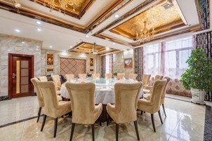 Un comedor formal con una mesa redonda, varias sillas y una araña.