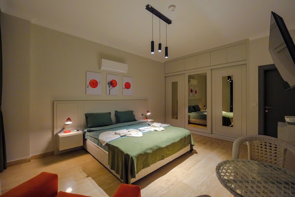 A modern bedroom with a bed, bedside tables, a chair, and a wardrobe.
