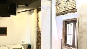 A modern hotel room with a bed, a chair, and a window. - Apartment 2 Rooms MURILLO (Madrid)