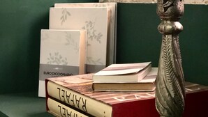 A stack of books with visible titles and a decorative metal object on a shelf. - Apartment 2 Rooms MURILLO (Madrid)