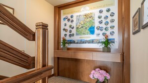 A wooden reception desk with a map and photos of Venice, a potted plant, and a framed picture on the wall. - Borgo Tabari Appartamento Renoir (Mussolente)
