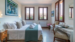 A hotel room with a bed, a desk, a chair, and two windows. - Borgo Tabari Appartamento Renoir (Mussolente)