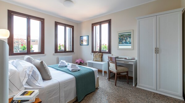 Ein Hotelzimmer mit Bett, Schreibtisch, Stuhl und Kleiderschrank.