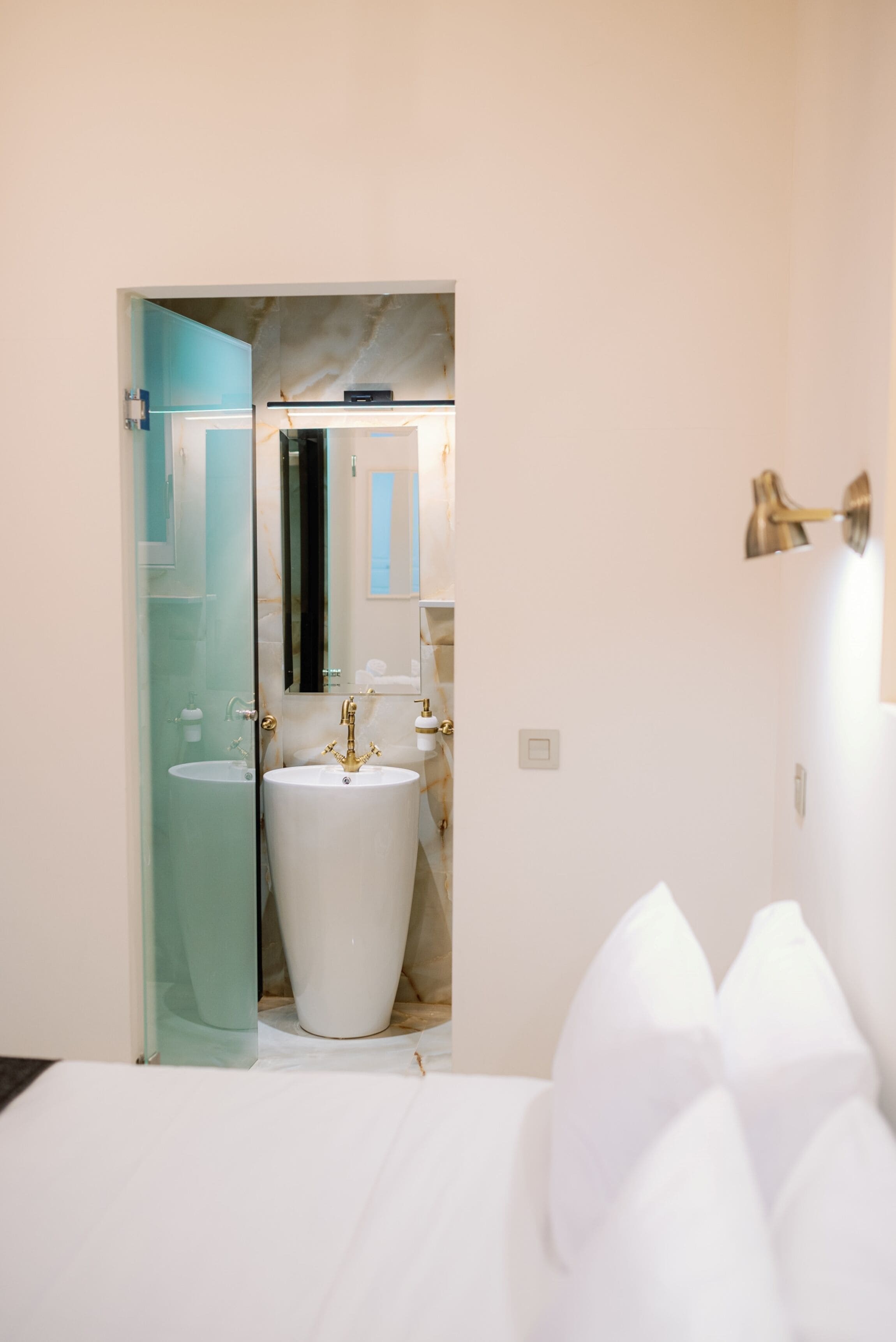 Un bagno moderno con un ampio lavandino bianco, una cabina doccia in vetro e uno specchio.