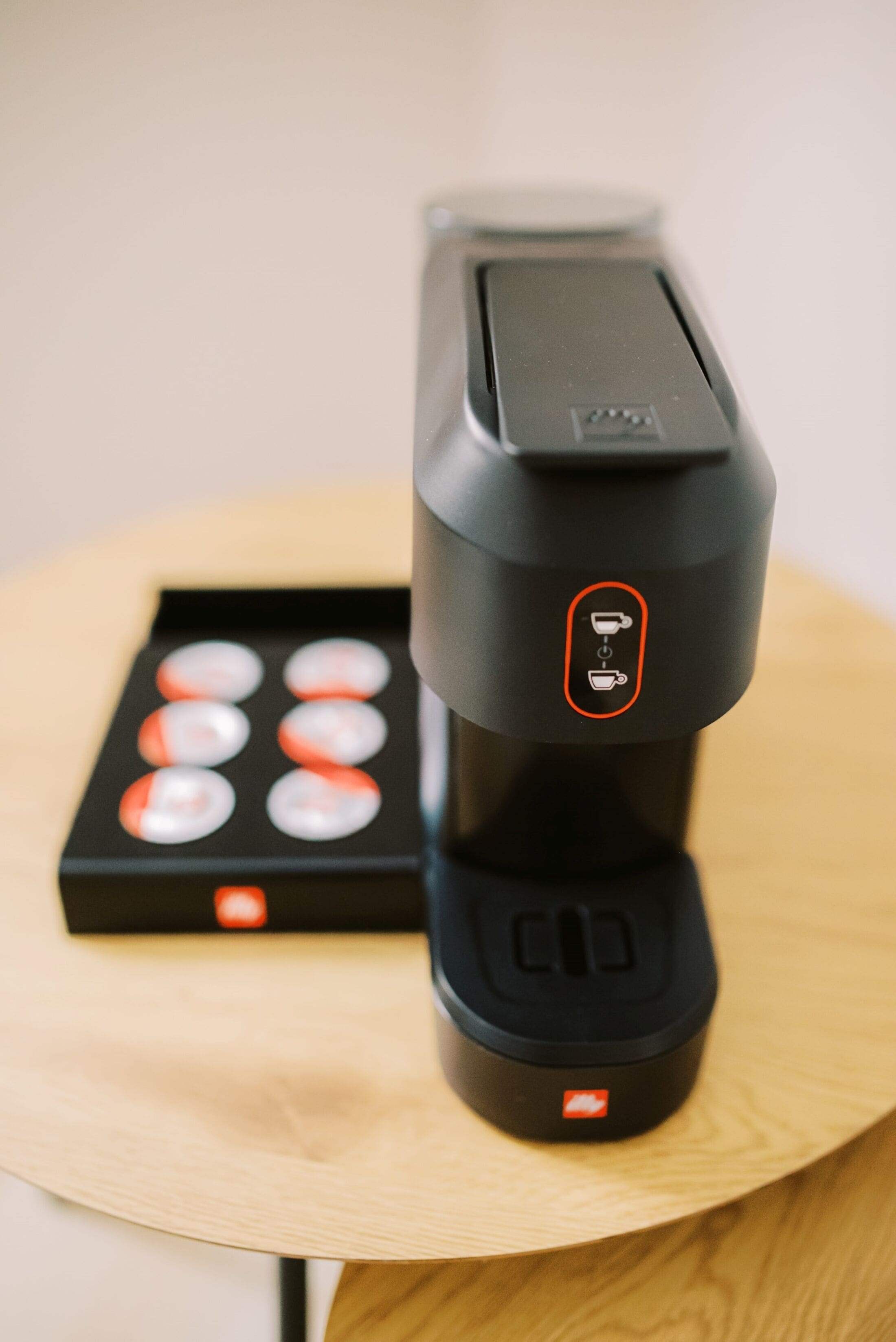 A coffee machine with a control panel and a coffee pod holder.