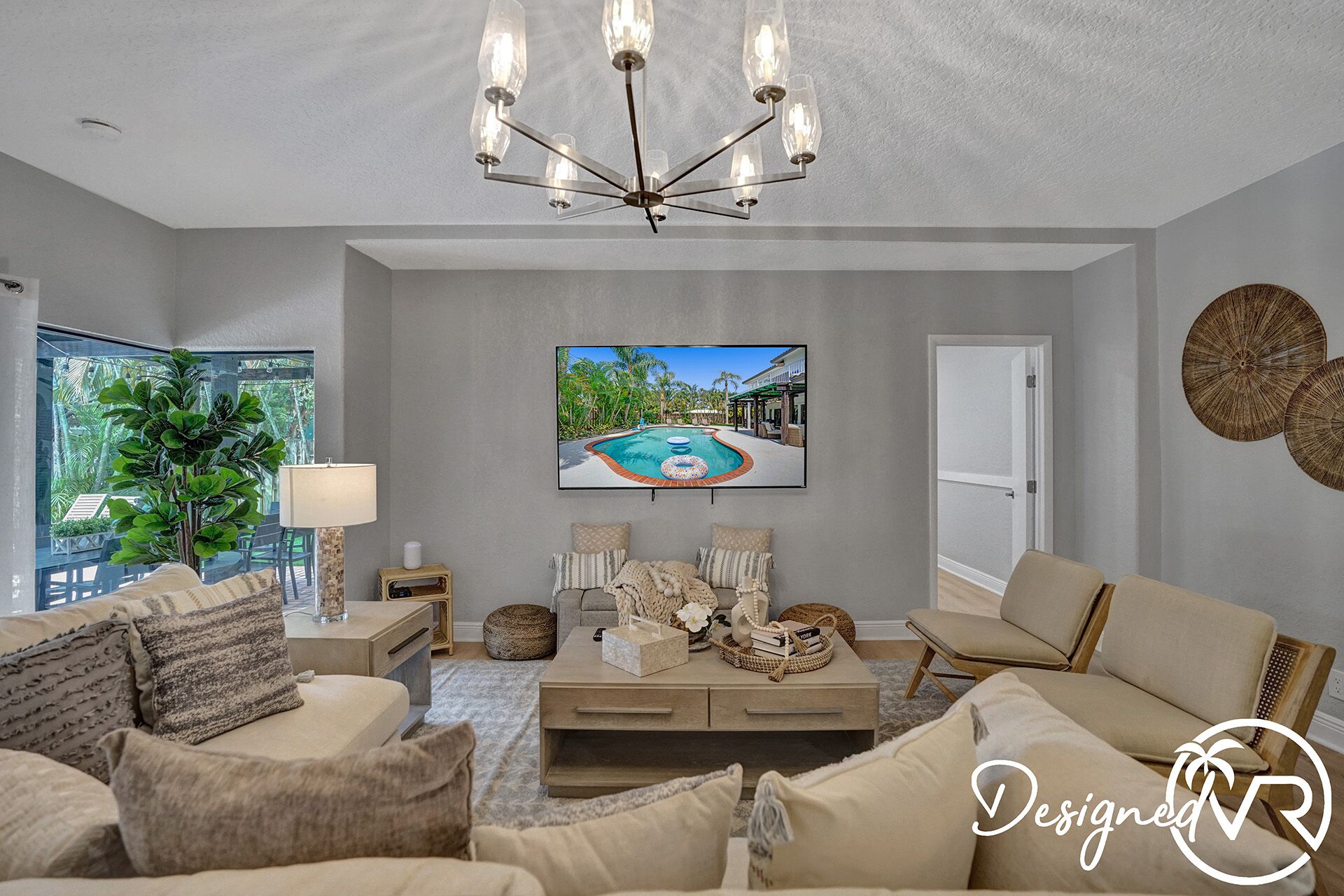 Una sala de estar moderna con un televisor grande, asientos cómodos y vistas a una piscina.