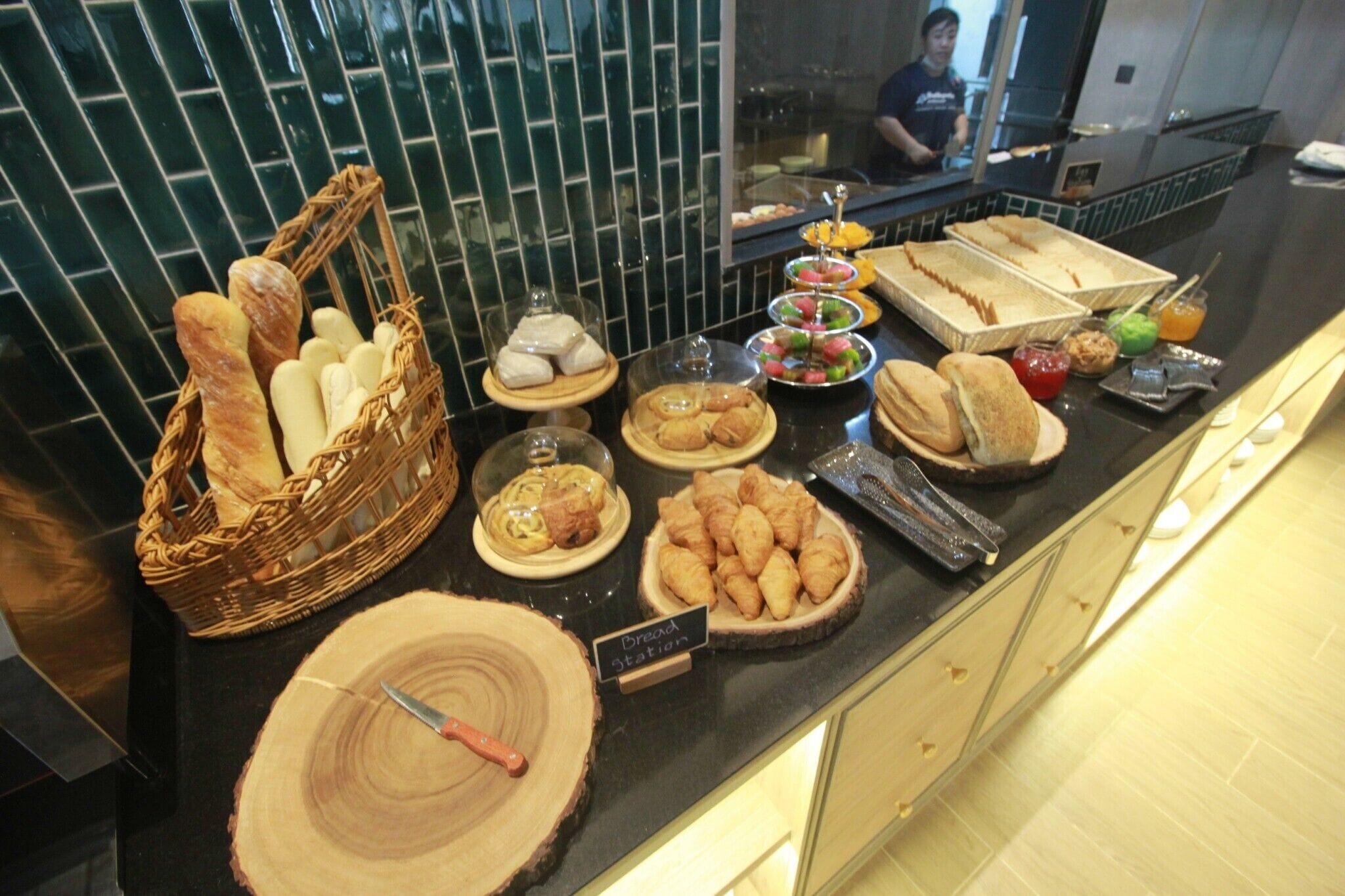 A breakfast buffet with various pastries, bread, and beverages.