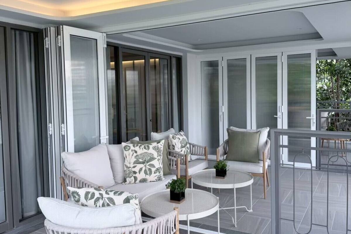 A modern living room with a sofa, armchairs, and a small table.
