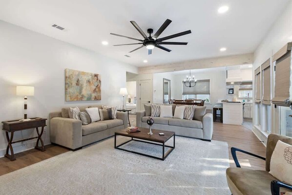 - Spacious open concept layout with plush sofas & sleek ceiling fan, perfect for movie nights & downtime - Warm wood floors & neutral tones offer a clean, calming backdrop - Natural light flows from windows to kitchen, making every corner feel bright - Coastal home w/ bikes & fenced yard (Santa Rosa Beach)