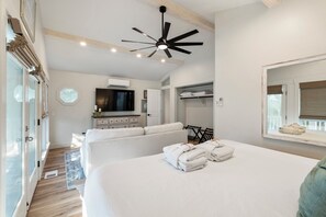 Relax in a spacious room with a large bed, flat-screen TV, and wardrobe.