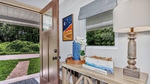 A wooden console table with a book titled "Black Mountain," a vase with white flowers, and a lamp. - Bear Walk Cottage in Black Mountain (Black Mountain)